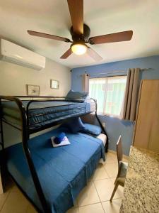 a bedroom with a bunk bed with a ceiling fan at Charming condo with a rooftop, across beach in Coco