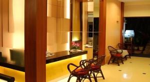 una stanza con sedie e una cucina con bancone di Hotel Minahasa a Manado