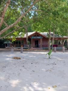 a building on the beach with trees in front of it at Togean Pulotiga Resort in Popolii