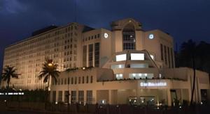 un grande edificio con una palma di fronte di Hotel Ruposhi Bangla a Bāg Noādda