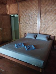 a bed in a room with two towels on it at Togean Pulotiga Resort in Popolii