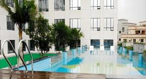 a swimming pool in front of a building at Oriental Glory Hotel in Dongguan