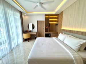 a bedroom with a large white bed and a desk at Rusa by The Lake in Baturiti