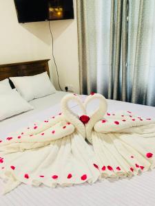 two swans shaped like hearts are on a bed at Gold Stream Villa in Demodara