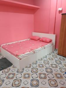 a pink bedroom with a bed with pink walls at Destiny Lodge & Homestay in Nāzirā