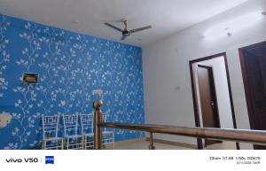 a room with blue wallpaper and blue chairs at Vishal guest house in Juliāsar
