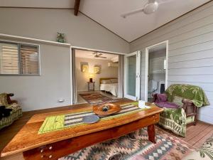 a room with a wooden table and a bedroom at Coolamon in Ballina