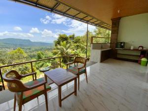 a balcony of a house with a table and chairs at Rumah Bagus Jayanti in Sidemen