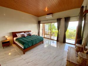 a bedroom with a bed and a large window at Rumah Bagus Jayanti in Sidemen