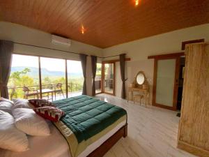 a bedroom with a large bed and a balcony at Rumah Bagus Jayanti in Sidemen +6 photos