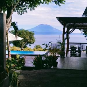 a resort with a view of the ocean and a mountain at Bataran Garden Cottage in Nusa Penida