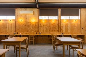 a restaurant with wooden walls and tables and chairs at IkazawaYumotokan in Minami Uonuma