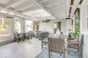a patio with tables and chairs and a tub at 3-Acre Retreat, 3 Mi to Dtwn Jensen! Upscale Home in Jensen Beach