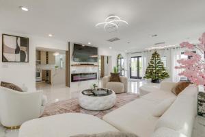 a living room with a white couch and a christmas tree at 3-Acre Retreat, 3 Mi to Dtwn Jensen! Upscale Home in Jensen Beach