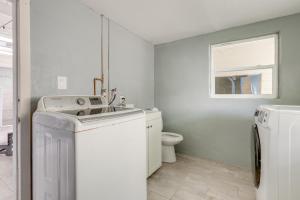 a white laundry room with a washer and dryer at 3-Acre Retreat, 3 Mi to Dtwn Jensen! Upscale Home in Jensen Beach +16 photos