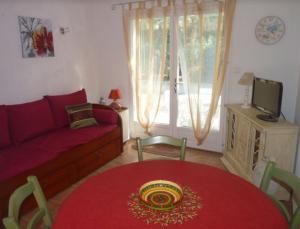 a living room with a red table and a couch at Le Mazet 40 in Saint-Rémy-de-Provence