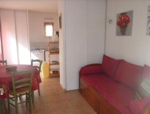 a living room with a red couch and a table at Le Mazet 40 in Saint-Rémy-de-Provence