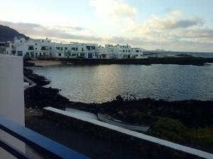 a group of white houses on the water with boats at Brisamarina de Órzola in Órzola