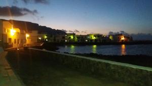 a group of houses and a body of water at night at Brisamarina de Órzola in Órzola