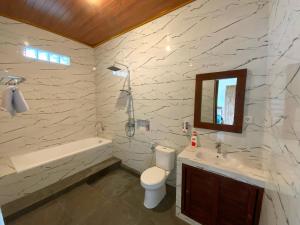 a bathroom with a toilet and a sink and a mirror at Rumah Bagus Jayanti in Sidemen