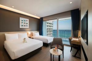 a hotel room with two beds and a balcony at St. John's Hotel in Gangneung