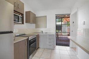 a kitchen with a sink and a stove at 1/24 Birch Street in Amity Point +4 photos