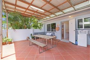 a patio with a wooden table and a bench at 1/24 Birch Street in Amity Point