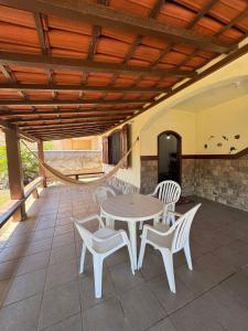 a patio with a table and chairs on a patio at Casa com piscina Perto Da Praia Em FIGUEIRA in Arraial do Cabo