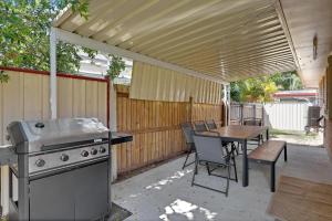 a patio with a grill and a table with chairs at Barefoot Haven in Amity Point