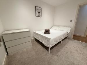 a bedroom with a bed with a teddy bear on it at Sleek Modern 2BDR Flat in Charming Pinner in Northwood