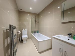 a white bathroom with a sink and a toilet at Sleek Modern 2BDR Flat in Charming Pinner in Northwood