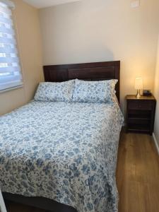 a bedroom with a bed with a blue comforter at Cabañas Perlas del Sur in Valdivia