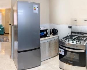 a stainless steel refrigerator in a kitchen with a stove at Cabañas Perlas del Sur in Valdivia