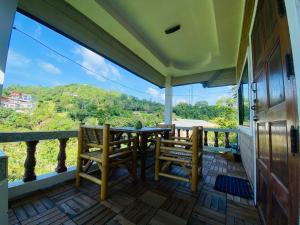 een veranda met 2 stoelen en een tafel op een balkon bij Sabai Homes 3 in Mae Haad