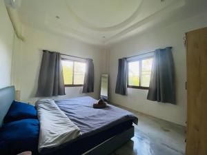 een slaapkamer met een bed en twee ramen bij Sabai Homes 3 in Mae Haad