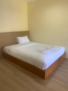 a bed with white sheets and pillows in a room at Nai Yang Guest House in Nai Yang Beach