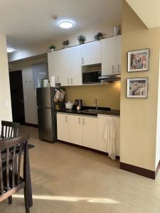 a kitchen with white cabinets and a black refrigerator at 2 Bedroom Condominium in Cagayan de Oro
