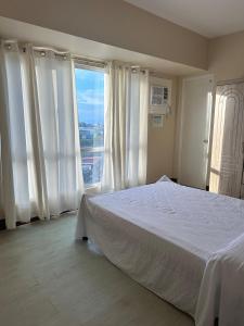 a bedroom with a bed and a large window at 2 Bedroom Condominium in Cagayan de Oro
