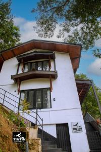 a white house with a window and stairs at Tin Tin Lodge in Ella