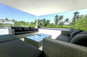 a patio with couches and a table and trees at Tropical Luxury Samui Villa Donava in Nathon Bay