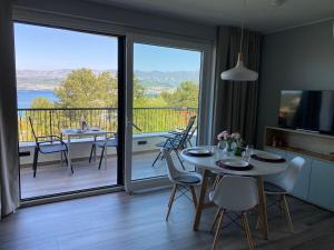a dining room with a table and a balcony at Vila Primorka-Apartmani Lavanda in Šilo