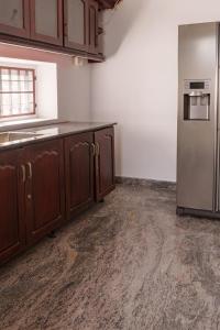 a kitchen with wooden cabinets and a stainless steel refrigerator at Orma in Cochin +3 photos