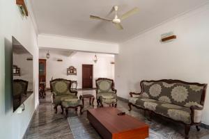 a living room with a couch and chairs and a table at Orma in Cochin