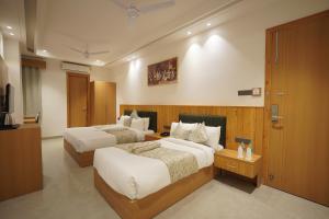 a hotel room with two beds and a television at Hotel Northern Heights in Amritsar +41 photos