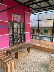 un edificio rosa con una panchina davanti di Villa berastagi murah bukit asri a Medan Altre 2 foto