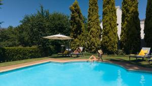 a woman laying on the edge of a swimming pool at Webersburg in Stellenbosch