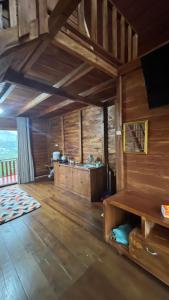 a large room with wooden walls and wooden floors at Padangsari Cabin House in Diyeng