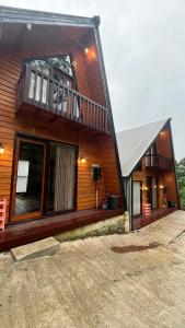 a wooden house with a balcony on the side of it at Padangsari Cabin House in Diyeng