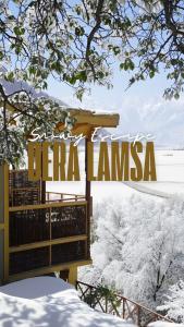 een bord voor een hotel in de sneeuw bij Dera Lamsa Resort Shigar in Shigar