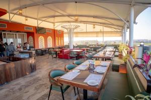 a restaurant with tables and chairs and people in the background at Ramnaa Hotel in Jāmb